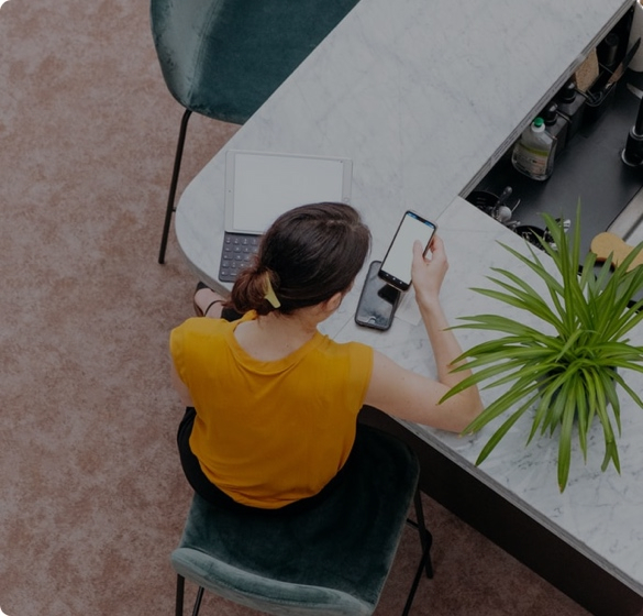 Overhead view of customer using smartphone while holding coffee cup showing mobile live chat experience