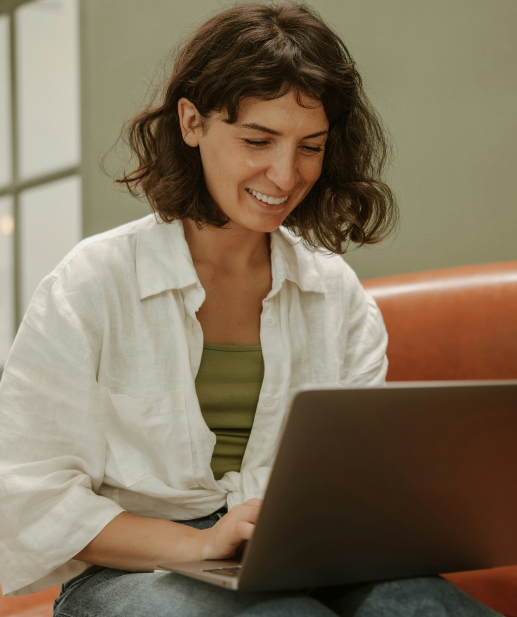 Woman working on laptop in bright natural lighting managing lead generation campaigns