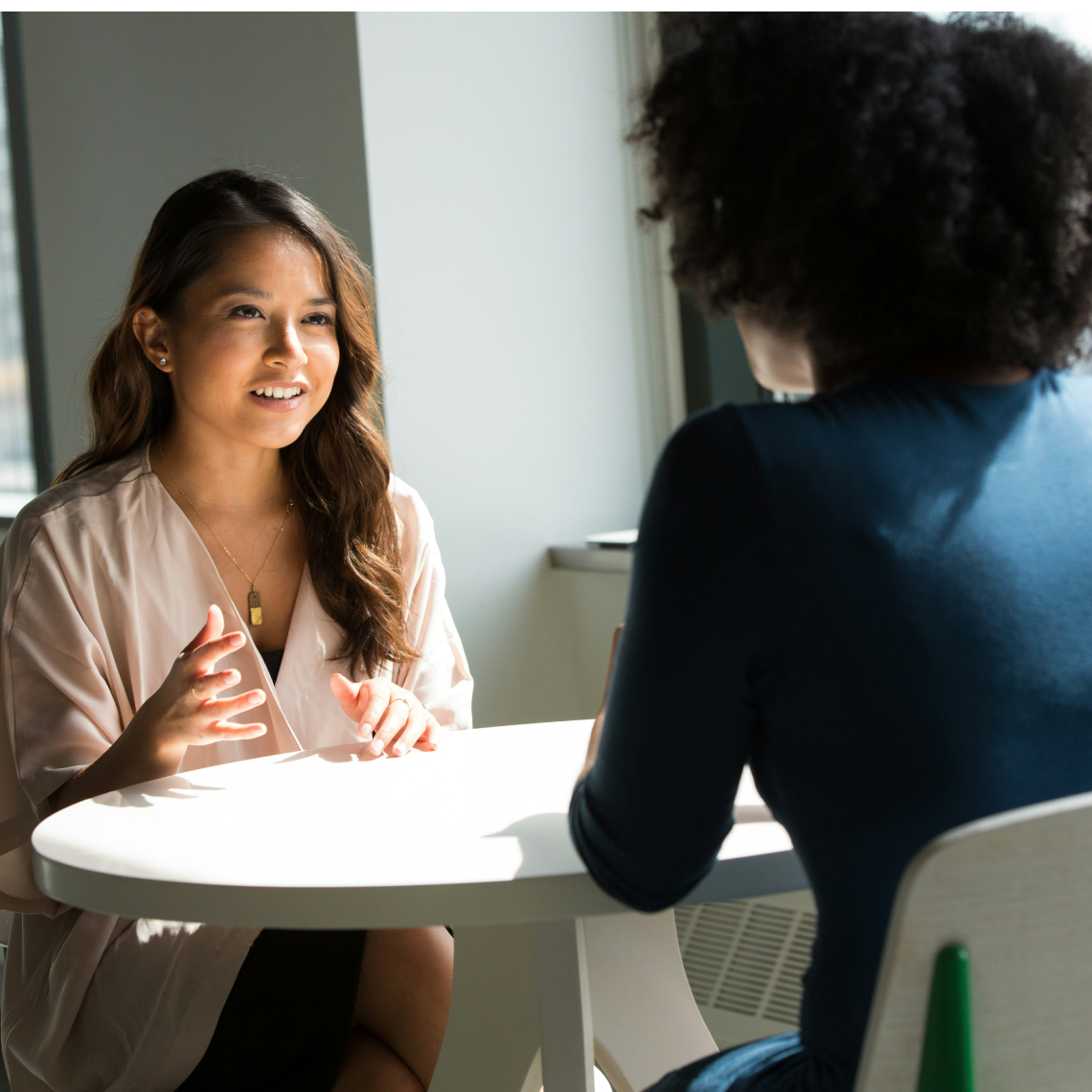 Smiling woman working on laptop in bright office space demonstrating personalized customer interaction